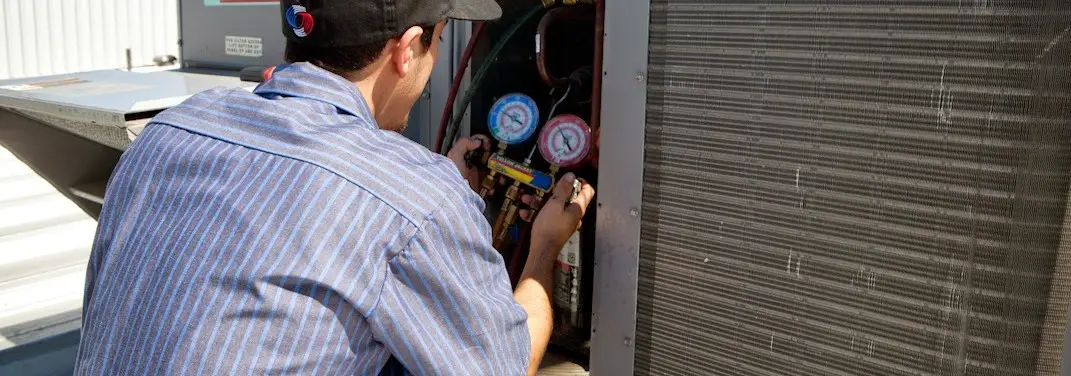 HVAC technician servicing a condenser unit in Bullard