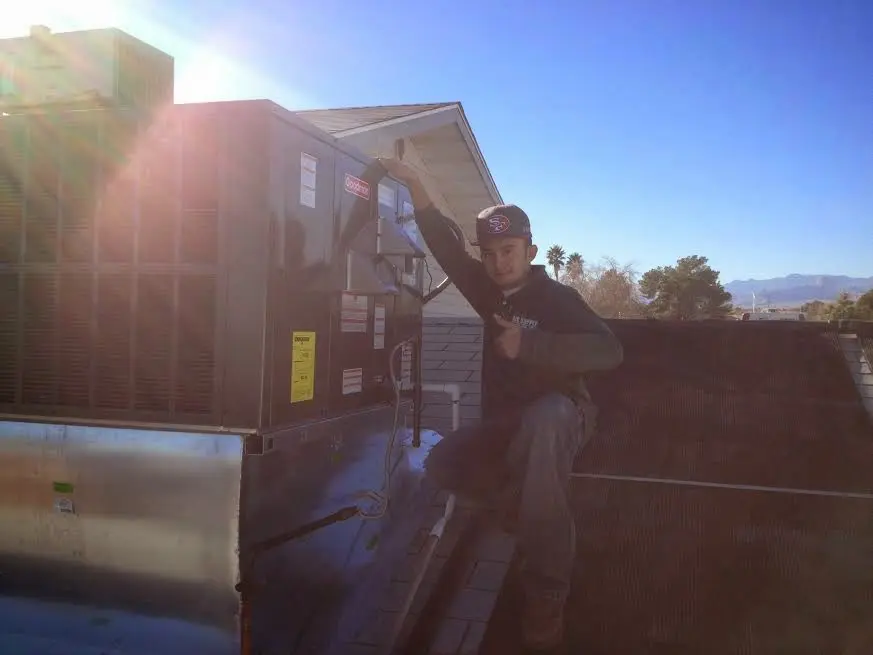 HVAC technician performing Boiler Repair on a rooftop unit in Bullard